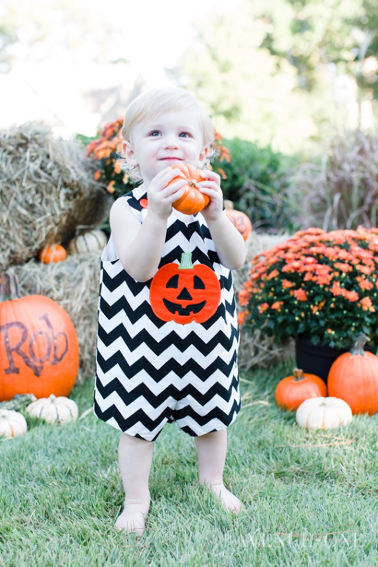 little boy holding small pumpkin