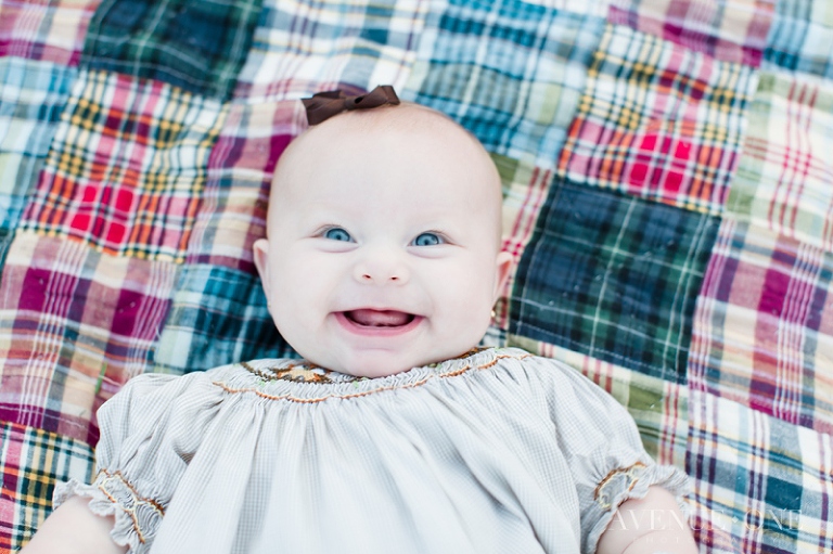 baby smiling on plaid blanket