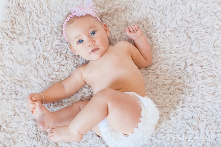 six month old girl holding feet