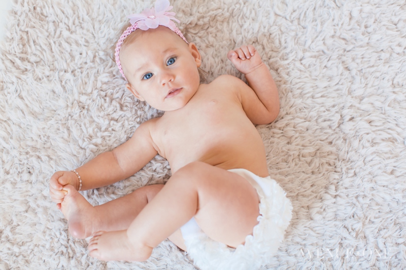 six month old girl holding feet