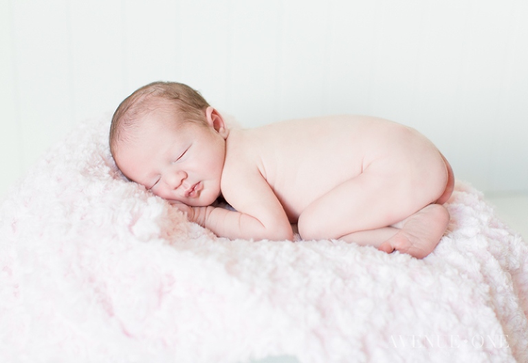 newborn baby on pink fuzzy blanket