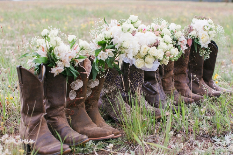 cowboy boots with bridesmaids bouquets in field
