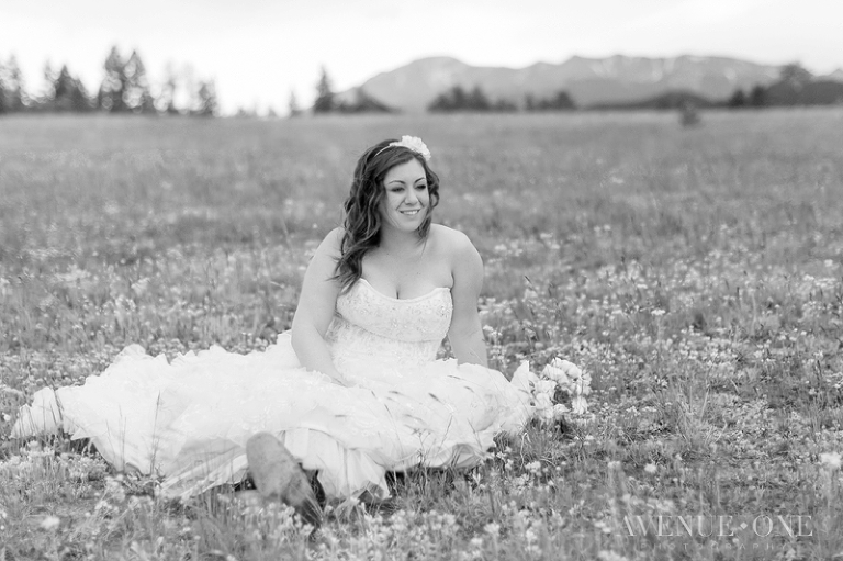 bride sitting in wildflower field
