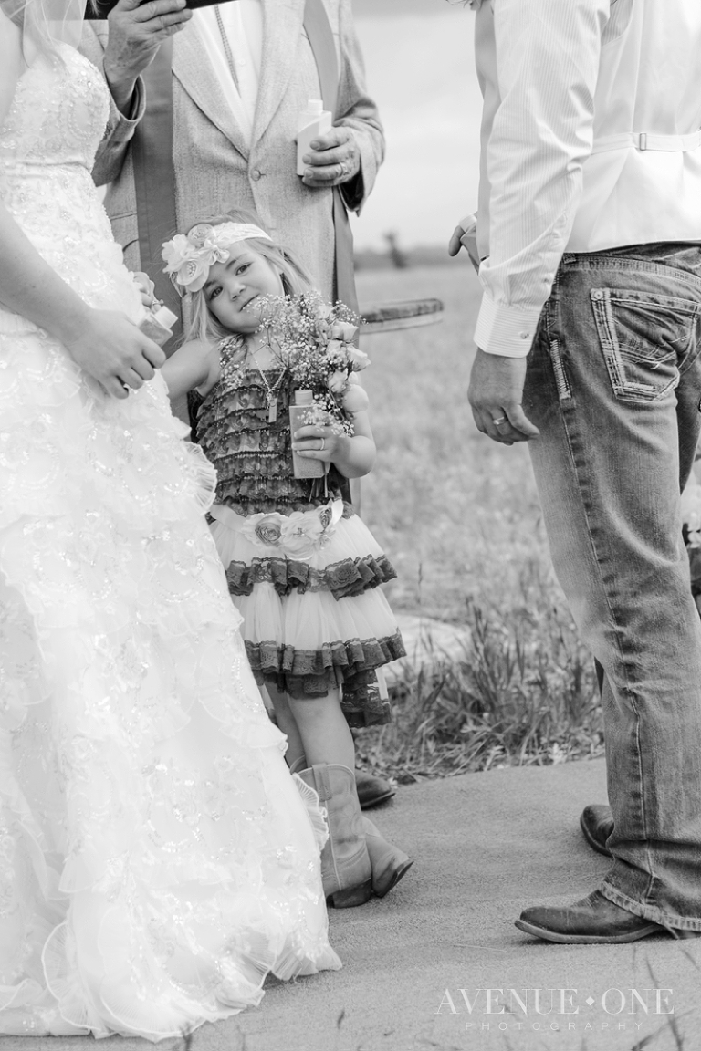 cute flower girl in middle of bride and groom