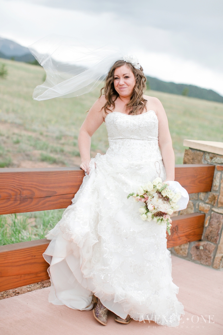 bride with veil blowing on bridge