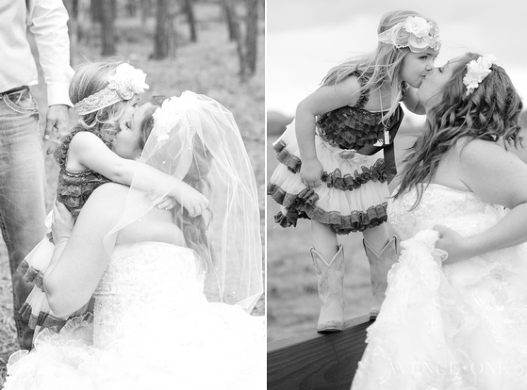 flower girl kissing bride on bridge