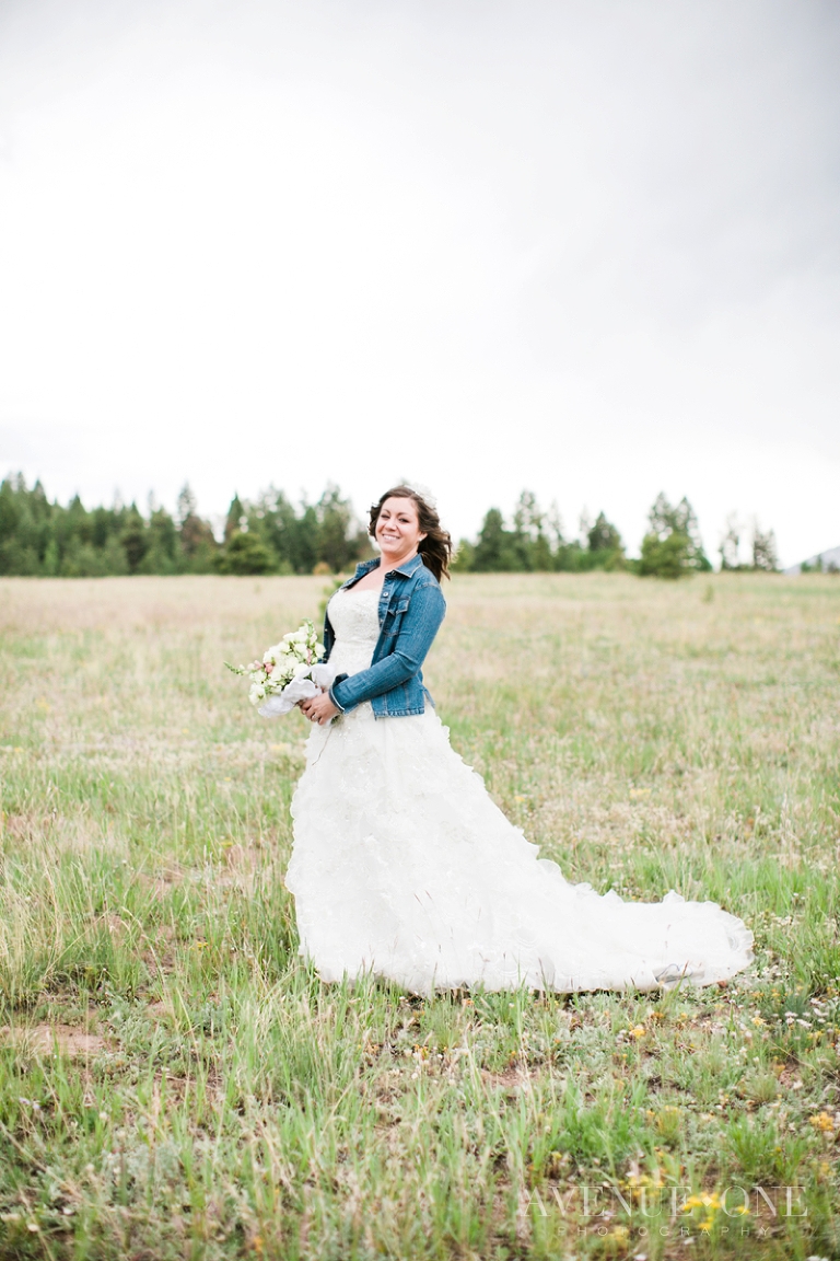 bride in field with jean jacket