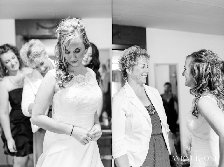bride putting dress on with mother
