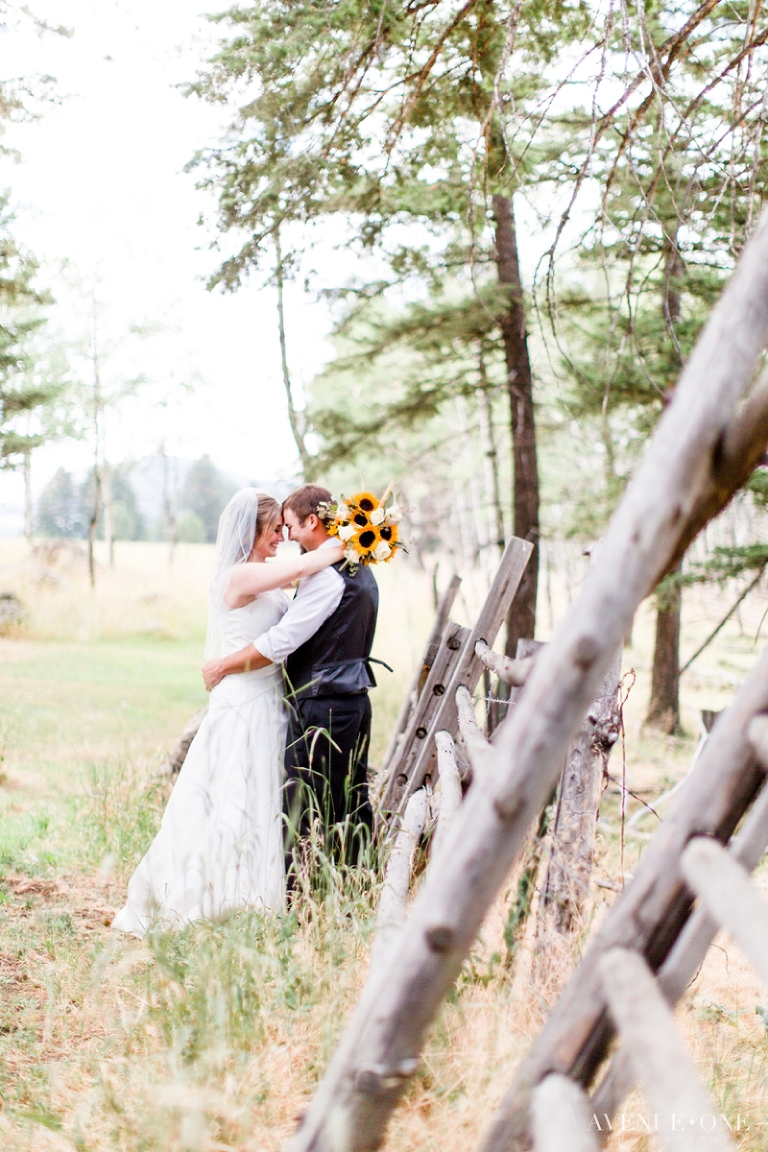 bride and groom by colorado fence