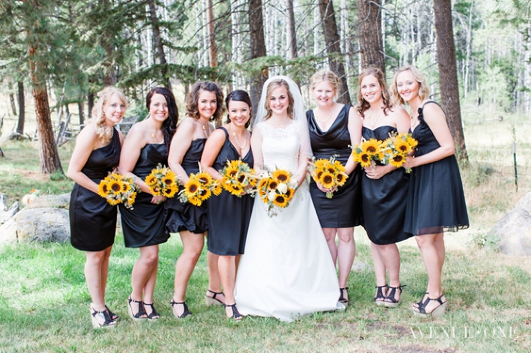 bridesmaids with black dresses and yellow sunflower bouquets