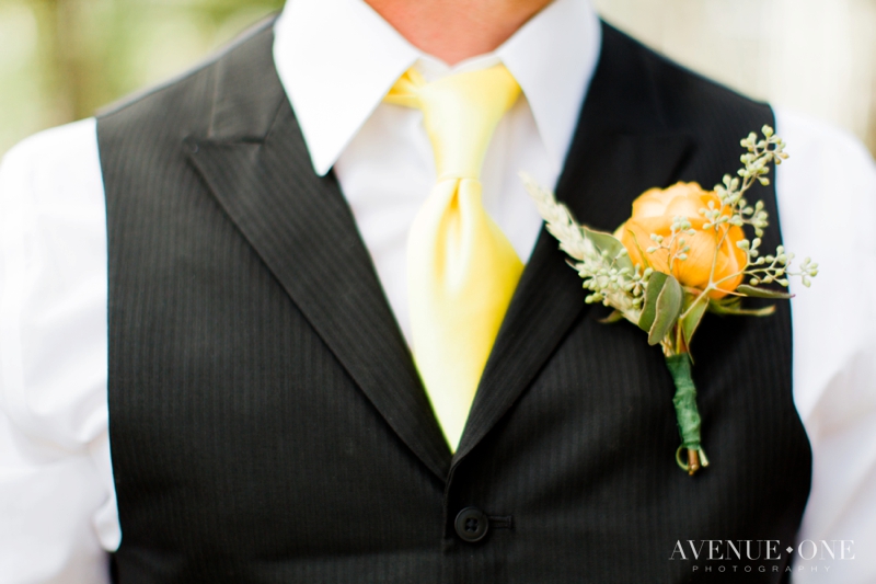 yellow boutonniere with black tux and yellow tie