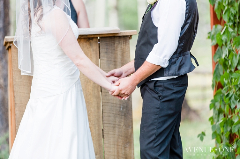 bride and groom holding hands during ceremony