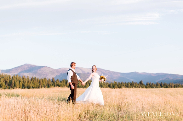 Bride leading groom through field