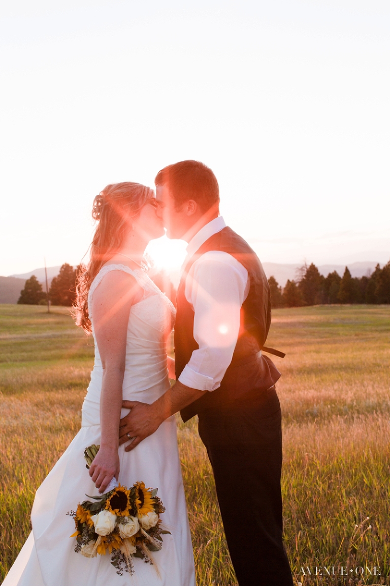 Colorado wedding bride and groom kissing with sun between them