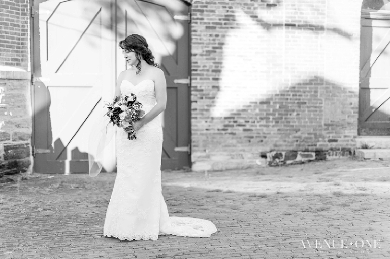 bride in front of brick wall with door